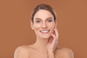 Woman with swatches of foundation on face against brown background