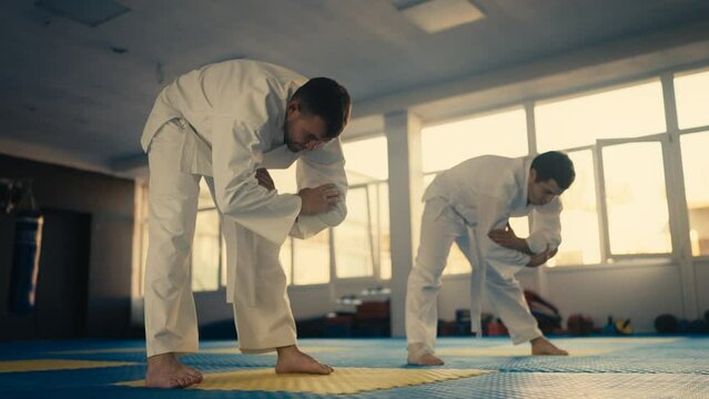 Two taekwondo practitioners stretching before practicing martial art in the gym