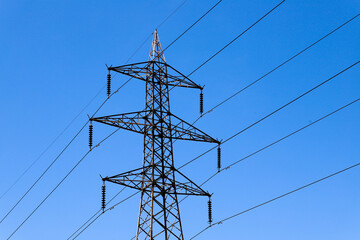 A power line tower with a blue sky in the background