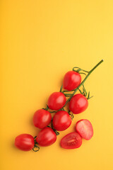 red cherry tomatoes on yellow background