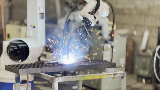 Robotic Arm engineer check on equipment in its with software of an Artificial Intelligence Computer Processor Unit.. Industrial factory employee working in metal manufacturing industry