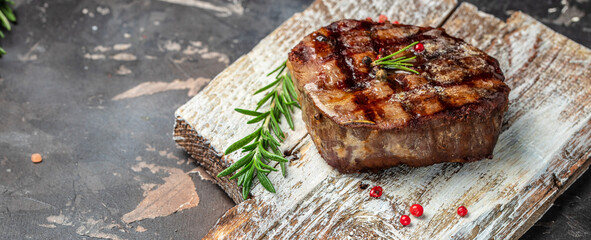 filet Mignon with a piece of butter on a wooden board. Long banner format. top view
