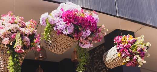 Banner decorative flowers hanging in basket . Entrance to flower shop or hotel