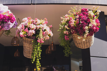 Obraz na płótnie Canvas Decorative flowers hanging in basket . Entrance to flower shop or hotel