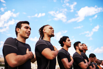 Play with all your heart. a team of young rugby players singing the national anthem before a game.