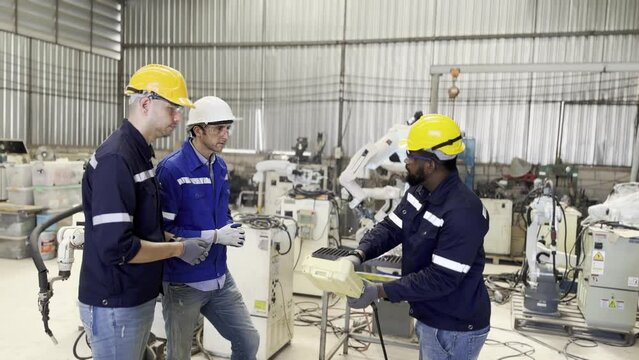 Robotic Arm engineer check on equipment in its with software of an Artificial Intelligence Computer Processor Unit.. Industrial factory employee working in metal manufacturing industry