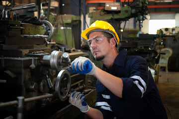 Lathe Operators Concentrated on Work. Worker in uniform and helmet works on lathe, factory. Industrial production, metalwork engineering, manufacturing.