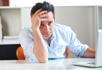 I cant take much more of this. a stressed out businessman using a laptop.