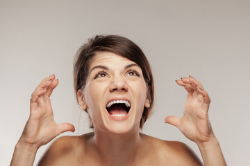 brunette girl screaming and making angry gesture with hands