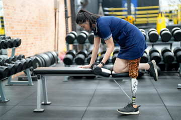 Fototapeta na wymiar Disabled athlete with leg prosthesis training at the gym. Paralympic Sport Concept.