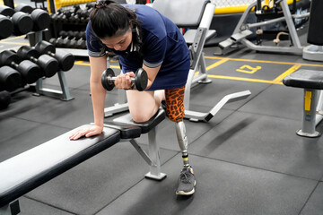 Disabled athlete with leg prosthesis training at the gym. Paralympic Sport Concept.