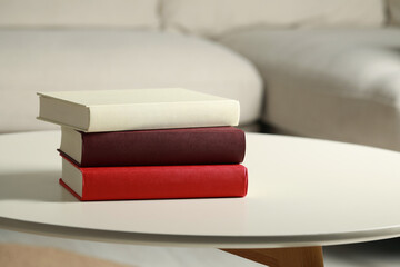 Many different books stacked on white table indoors, space for text