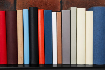 Many different hardcover books on black console table