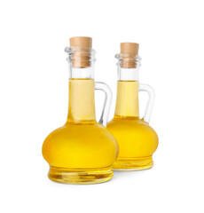 Glass jugs of cooking oil on white background