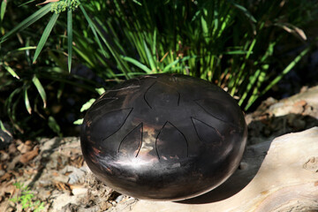 Steel tongue drum on ground outdoors. Percussion musical instrument