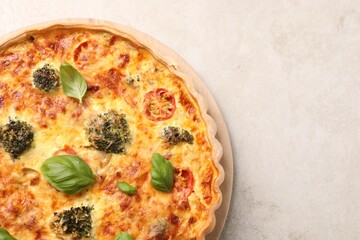 Delicious homemade vegetable quiche on light gray table, top view