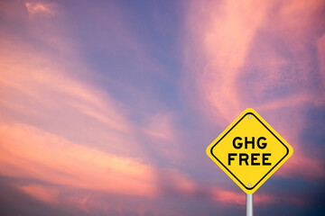 Yellow transportation sign with word GHG (Abbreviation of greenhouse gas) free on violet color sky...