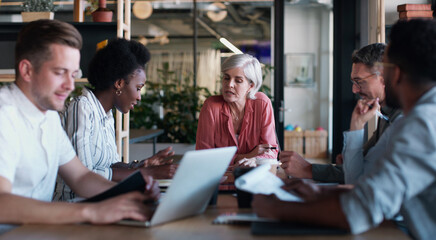 Meet up and maximise on success. a group of businesspeople having a meeting in a modern office.