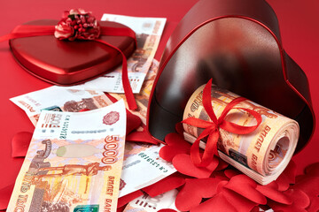 Fototapeta premium Russian rubles on red background, bundle of five thousand banknotes with red ribbon in heart box, money gift concept