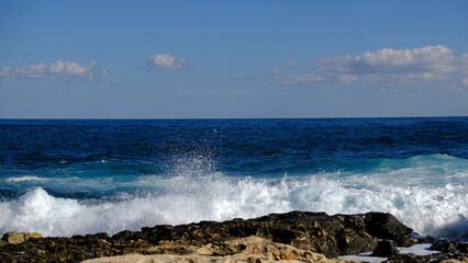 Blue sea wave and white foam and splash. Stone beach on island of Malta, no sandy beach. Summer holiday border frame concept. Tropical island vacation backdrop. Tourist travel banner design template.