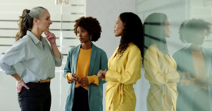 Diverse group of businesswomen talking during a casual meeting together in a bright modern office