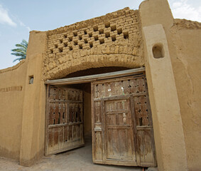 Old wooden entrance gate doorway in egyptian mud brick house