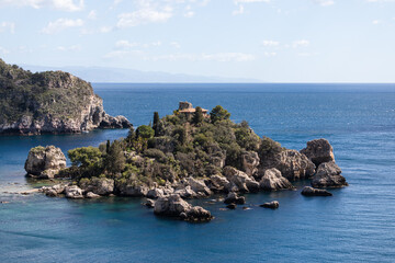 Fototapeta na wymiar Beautiful rocky island in Taormina, Sicily coast in Italy with deep blue sea
