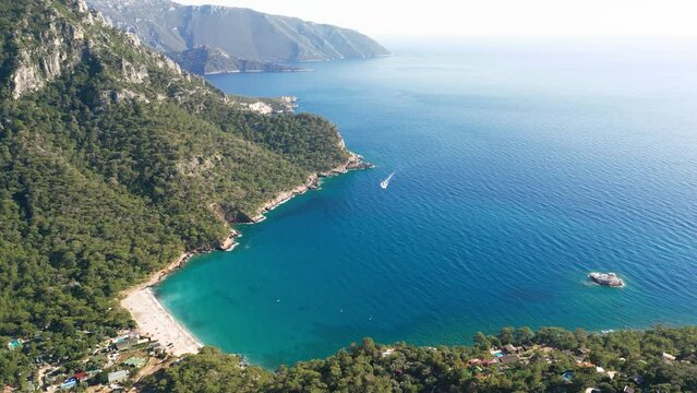 Drone high-angle photo of the mountain pass through the green hills by the turquoise Mediterranean sea in Mugla province, turkey