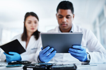 Obraz premium Whats tech support without cutting edge technology. a young man and woman using a digital tablet while repairing computer hardware in a laboratory.