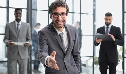 business and office concept - handsome buisnessman with open hand ready for handshake