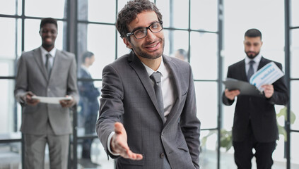 Fototapeta premium business and office concept - handsome buisnessman with open hand ready for handshake