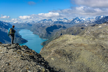 Fototapeta premium Wanderer auf dem Besseggen Grat mit Blick auf Gjende See, Jotunheimen Nationalpark, Norwegen