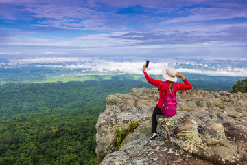 Young  woman hiking on mountains. Lan-hin-pum, Phu Hin Rong Kla National park, Phitsanulok province , Thailand.