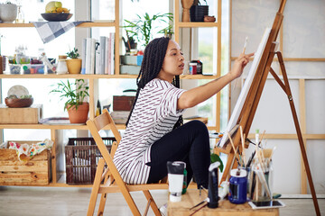 Painting requires you to be fully present in the moment. a beautiful young woman working on a...