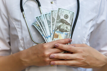 A few dollars in the hands of a doctor, close-up.
