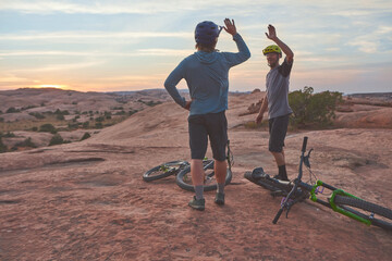 It doesnt get easier, you just get better. two men giving each other a high five while out mountain...