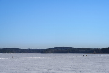 People walking on the ice of Lake Vesijarvi in winter. Vaaksy, Finland.