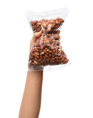 cooking and long shelf life food concept - hand holding plastic bag with raw peanuts isolated on white background