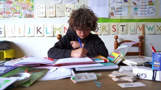 Europe, Italy  2023 - bay child 8 years old does his homework - study at school classroom equipped for children and school teaching