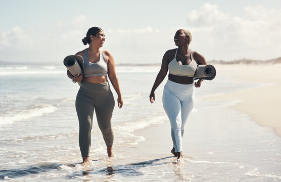 Yoga Makes Us Feel Like We Can Walk On Water. Two Young Women Walking On The Beach With Their Yoga Mats.