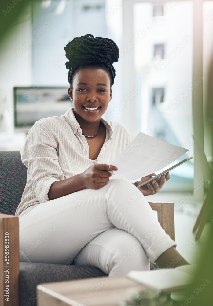 Canvas Prints Business has been booming lately. a businesswoman using her digital tablet while reading paperwork.