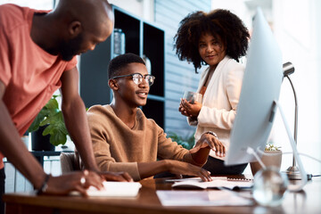 Youll never go wrong if you collaborate with great minds. a group of businesspeople looking at something on a computer screen in an office.