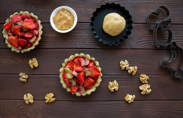 Tasty strawberry tart preparation on wooden rustic table, top view. 