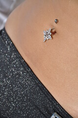 Female sunbathing in swimwear with shiny belly button piercing. Sexy tanning on stomach in the summer.