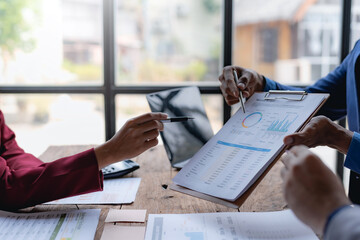 Naklejka premium Business people meeting explaining the financial graph data and marketing plan. Group of business people at meeting assessment the state of business investment and marketing...