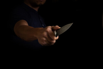 Adult Man Holding Sharp Knife in the Shadow. Concept Picture of Murderer, Killer, Assasin, Robber...