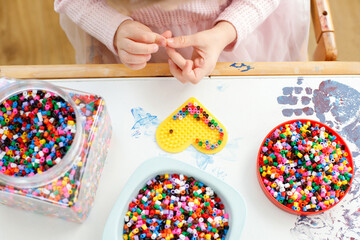 Close-up of Girl Playing with Hama Beads at Table