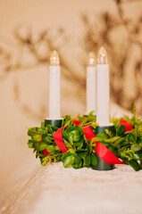 Plastic lingonberry crown with red satin ribbon and white electric lights. Saint Lucias traditional candlelight crown in closeup.