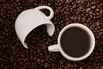 The journey from bean to cup. Closeup shot of two cups of coffee surrounded by coffee beans.