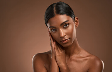 She got no dirt on me. Portrait of a beautiful young woman posing against a brown background.
